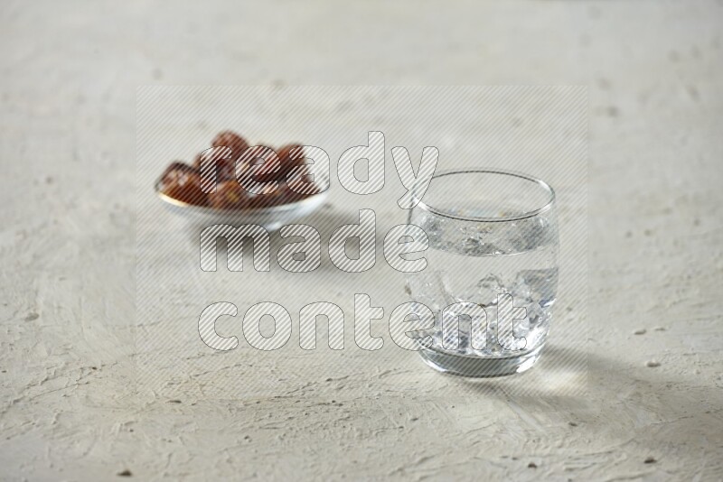 Cold drinks in a glass cup with dates such as water, tamarind, qamar eldin, sobia, milk and hibiscus on textured white background