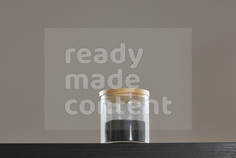 حبة البركة في وعاء زجاجي على خلفية سوداء