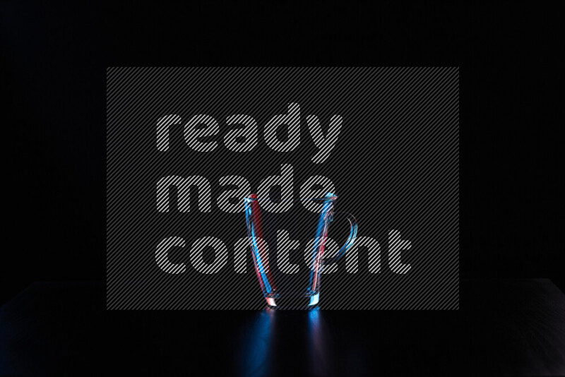 Glassware with rim light in red and blue against black background