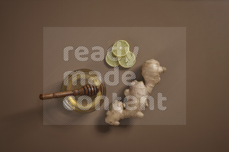 Fresh ginger root with different ingredients such as lemon, orange, honey, ground ginger on beige baackground