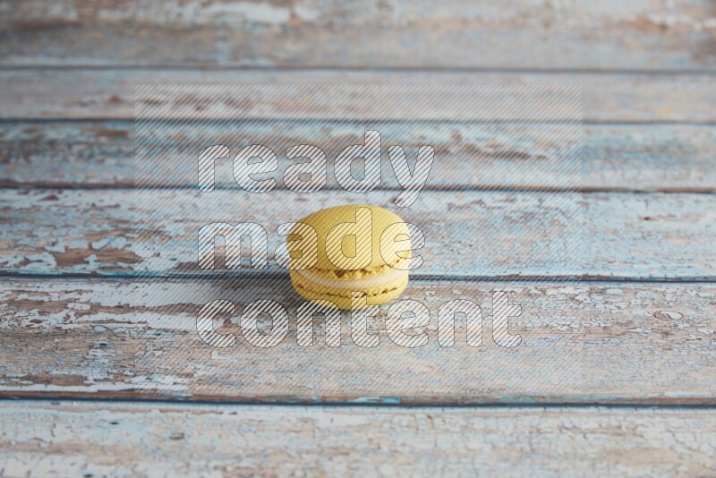45º Shot of Yellow Lime macaron on light blue wooden background