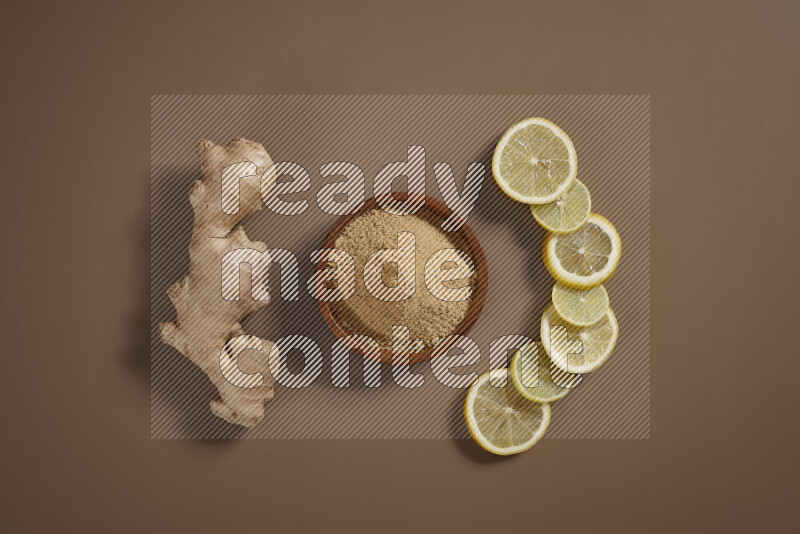 Fresh ginger root with different ingredients such as lemon, orange, honey, ground ginger on beige baackground