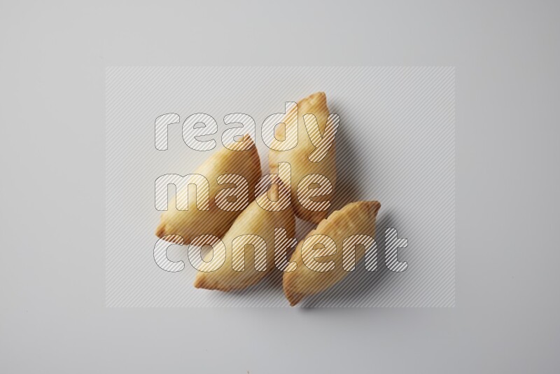 Four fried sambosa from a top angle on a white background