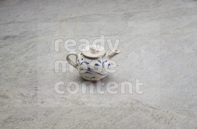 A pottery teapot on grey marble background