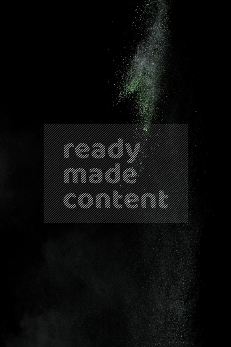 A side view of green powder explosion on black background