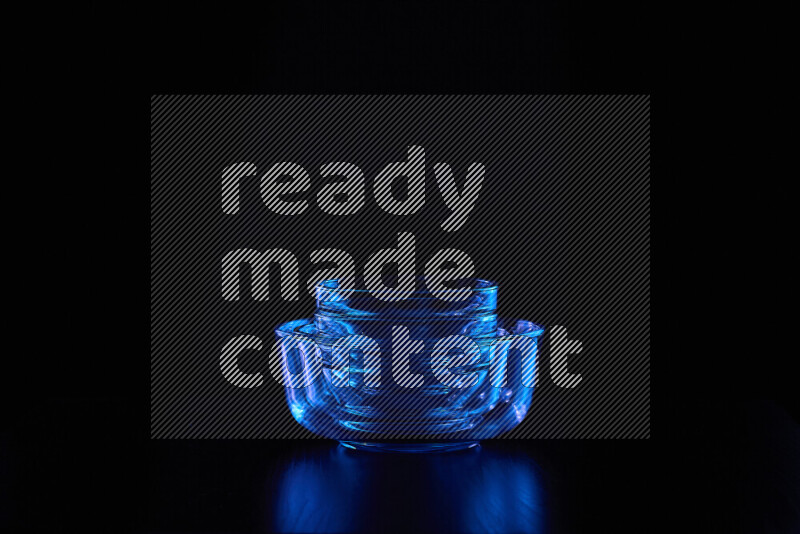 Glassware with rim light in blue against black background