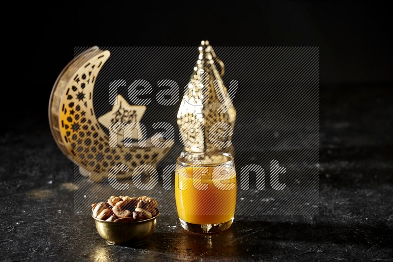 مكسرات في وعاء معدني مع مشروب قمر الدين بجانب فوانيس ذهبية علي خلفية سوداء