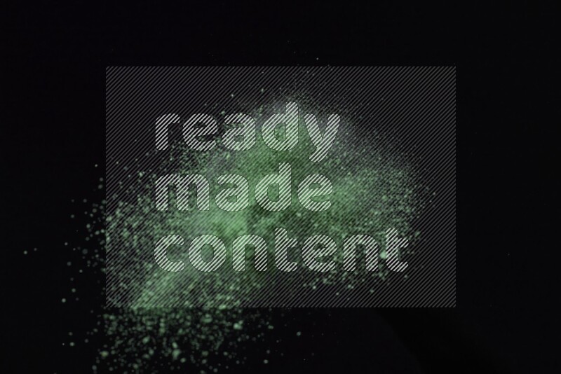 Green powder explosion on black background