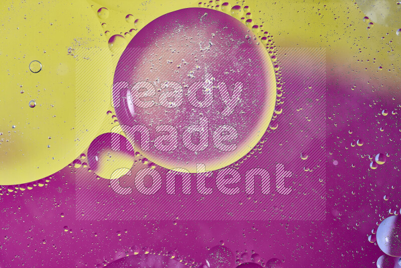 لقطات مقربة لفقاعات من الزيت على سطح الماء باللون الأصفر والوردي