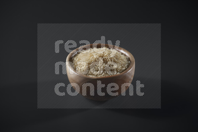 Basmati golden rice in a wooden bowl on grey background