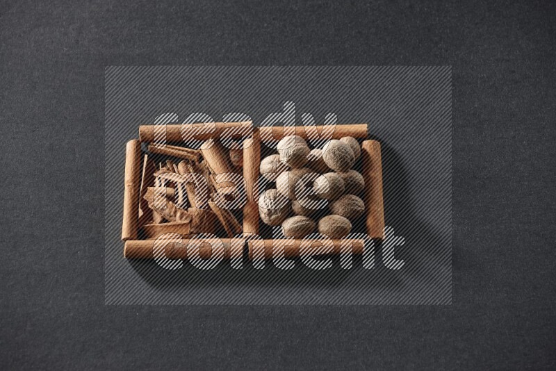 2 squares of cinnamon sticks full of cinnamon and nutmeg on black flooring