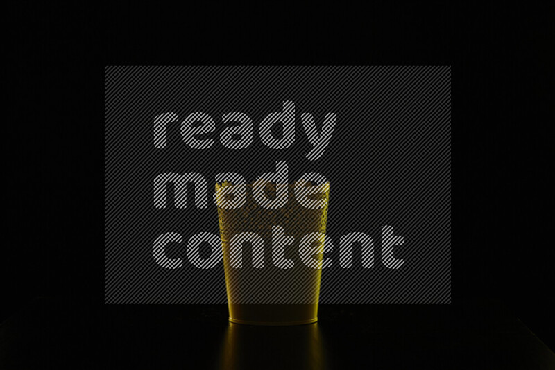 A plant pot with colored rim light against black background