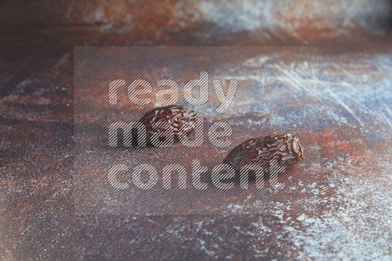 two madjoul dates on a rustic reddish background