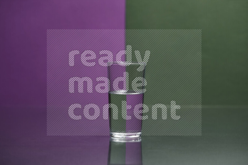 The image features a clear glassware filled with water, set against purple and dark green background