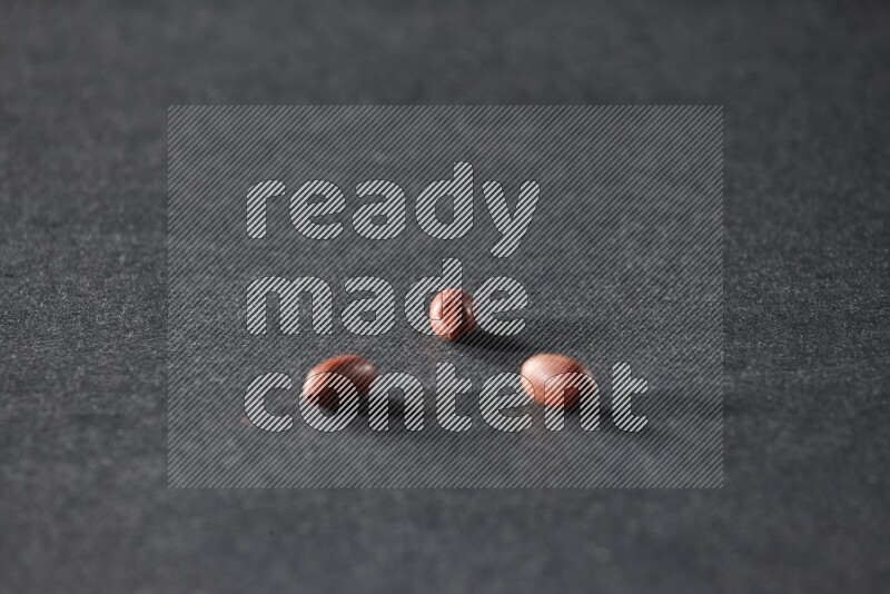 3 red skin peanuts on a black background in different angles
