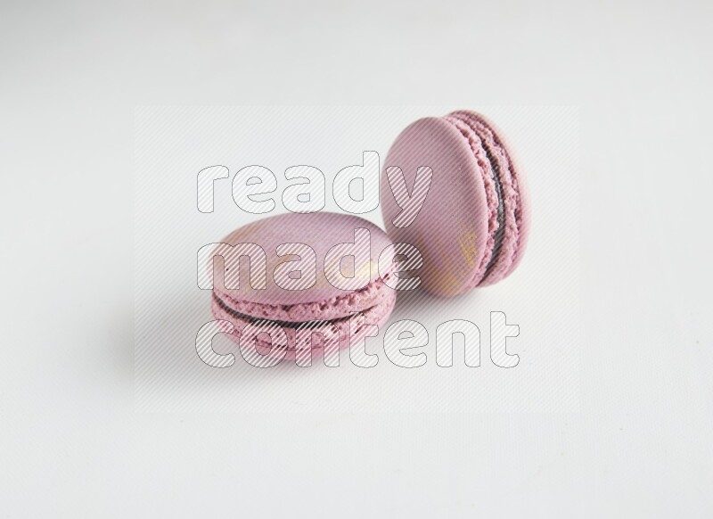 45º Shot of two Purple Strawberry macarons on white background