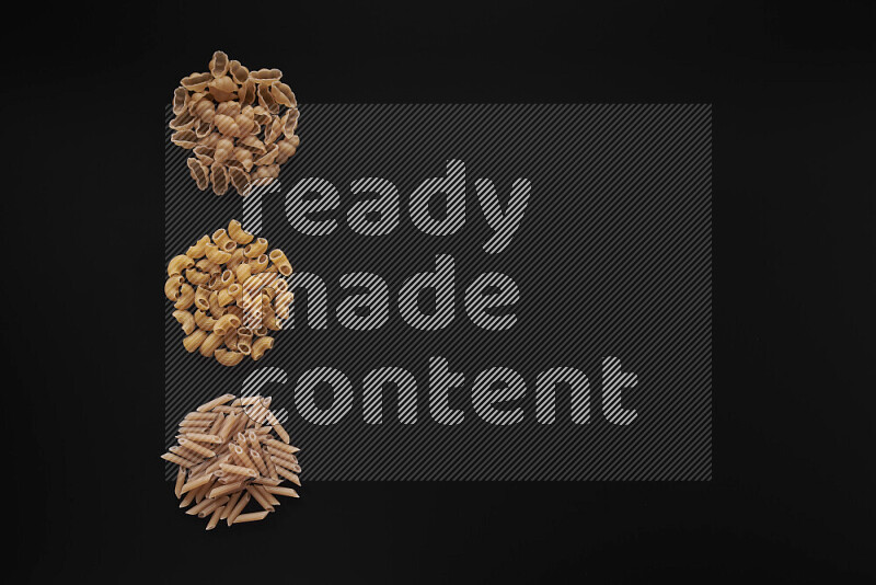 Different pasta types in 3 bunches on black background