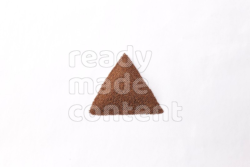 Garden cress seeds in a triangle shape on a white flooring