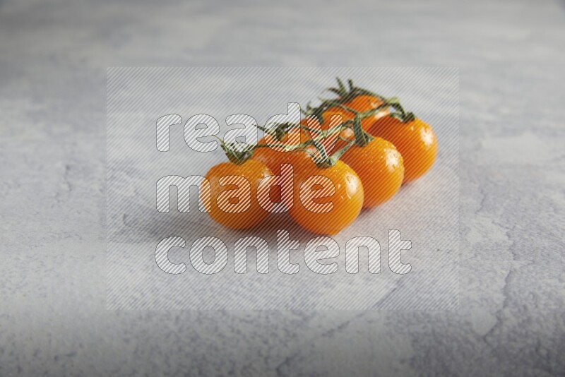 Orange cherry tomato vein on a light grey textured background 45 degree