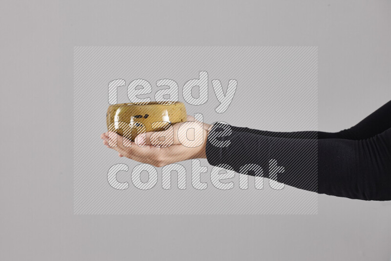 A woman in black abaya holding different pottery essentials in different positions
