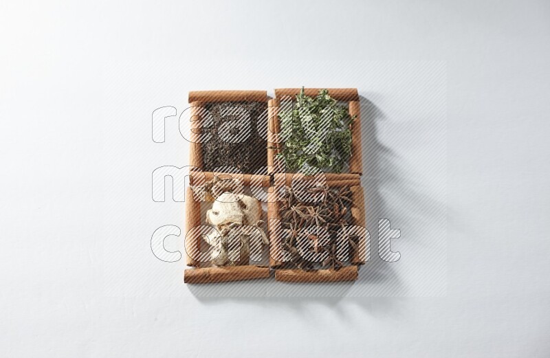 4 squares of cinnamon sticks full of tea, mint, star anise and ginger on white flooring