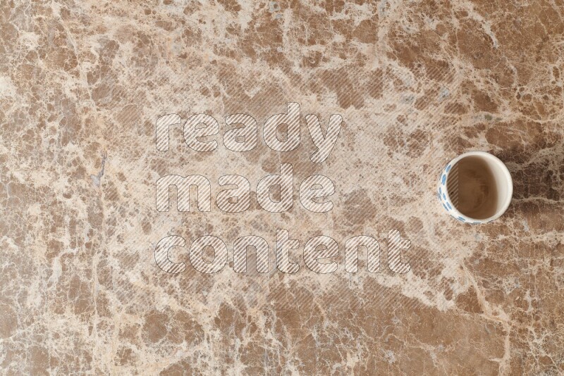 A pottery cup on beige marble background