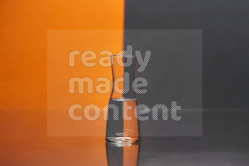 The image features a clear glassware filled with water, set against orange and black background