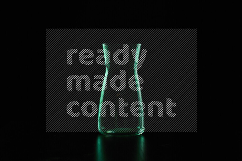 Glassware with rim light in green against black background