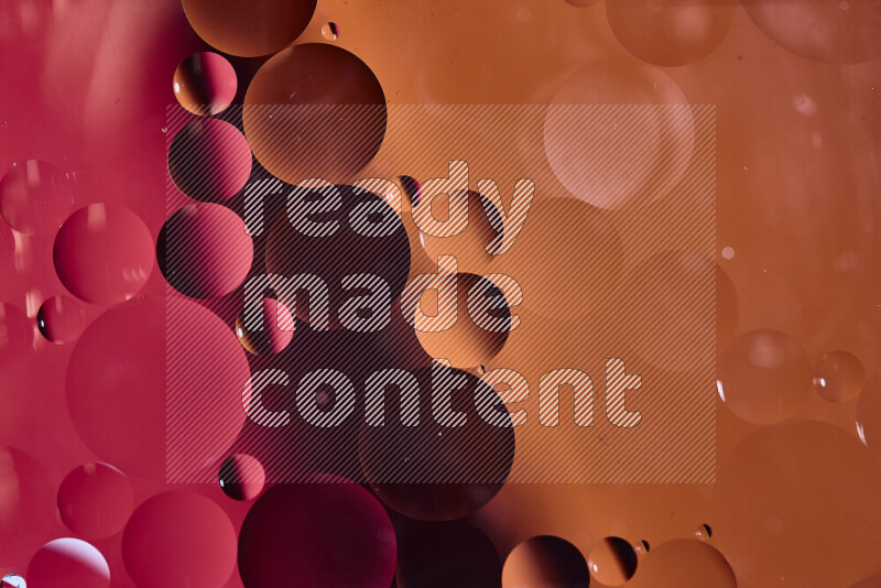 لقطات مقربة لفقاعات من الزيت على سطح الماء باللون الأحمر والبرتقالي