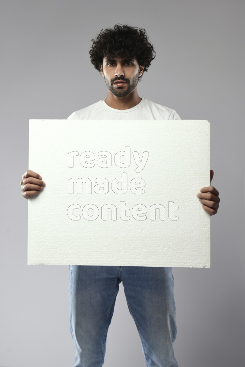A man wearing casual standing and holding a white board on white background