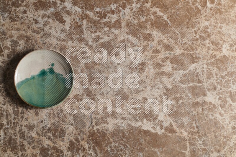 A decorative pottery plate on beige marble background