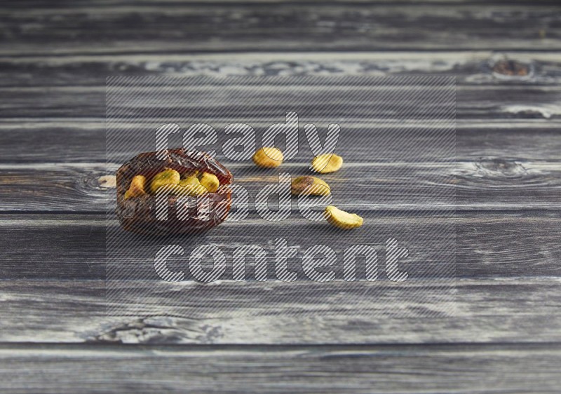 pistachio stuffed madjoul date on a wooden grey background