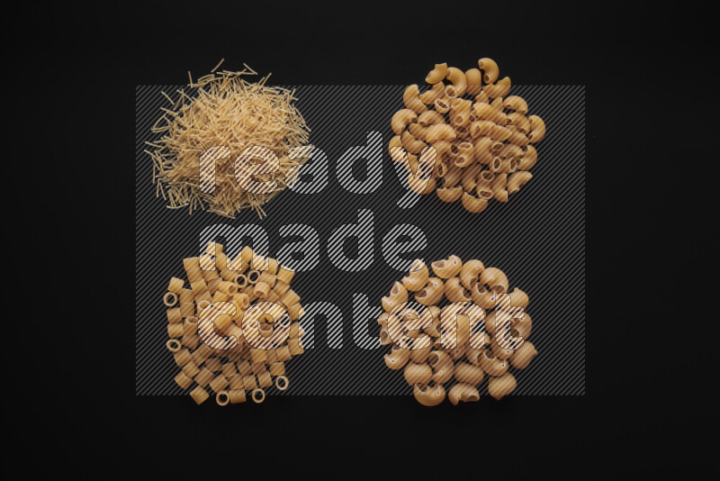 Different pasta types in bunches on black background
