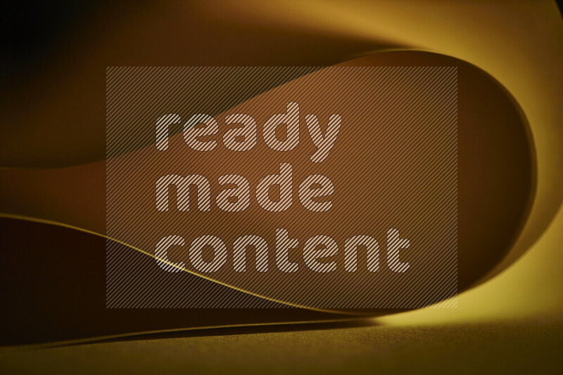 An abstract art piece displaying smooth curves in yellow gradients created by colored light