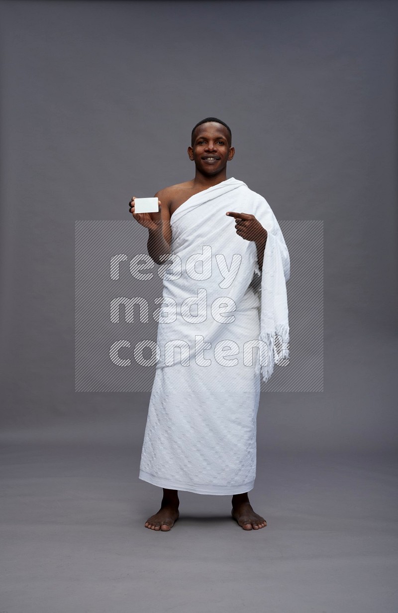 A man wearing Ehram Standing holding ATM card on gray background
