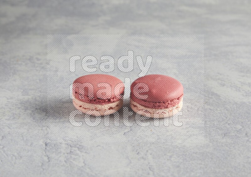 45º Shot of two Pink Litchi Raspberry macarons  on white  marble background