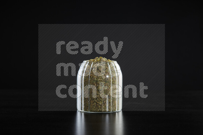 Freekeh in a glass jar on black background