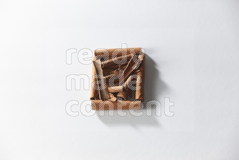 A single square of cinnamon sticks full of cinnamon on white flooring