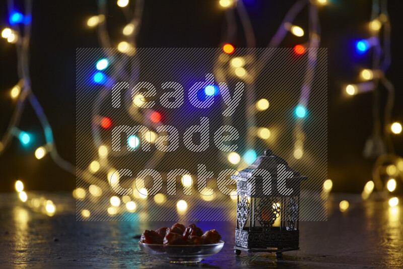 A traditional ramadan lantern surrounded by glowing fairy lights in a dark setup