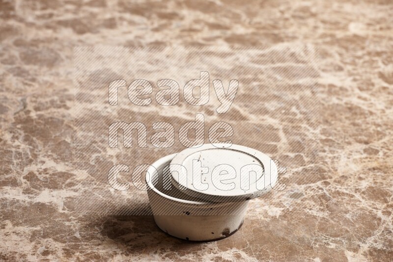 A white pottery bowl on beige marble background