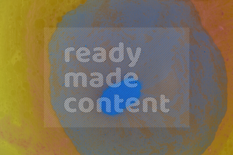 The image captures a dramatic splatter of blue paint over a orange backdrop