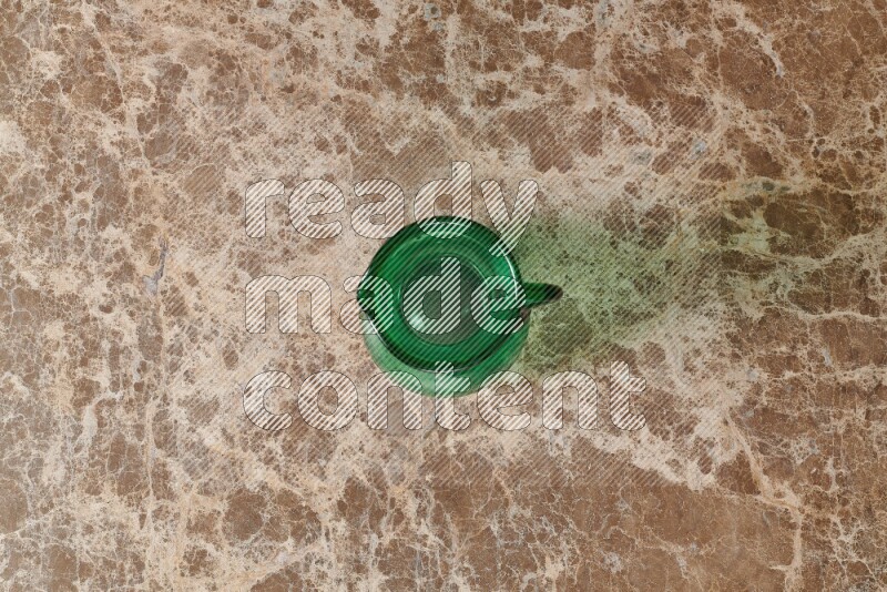 A colored glass jug on beige marble background