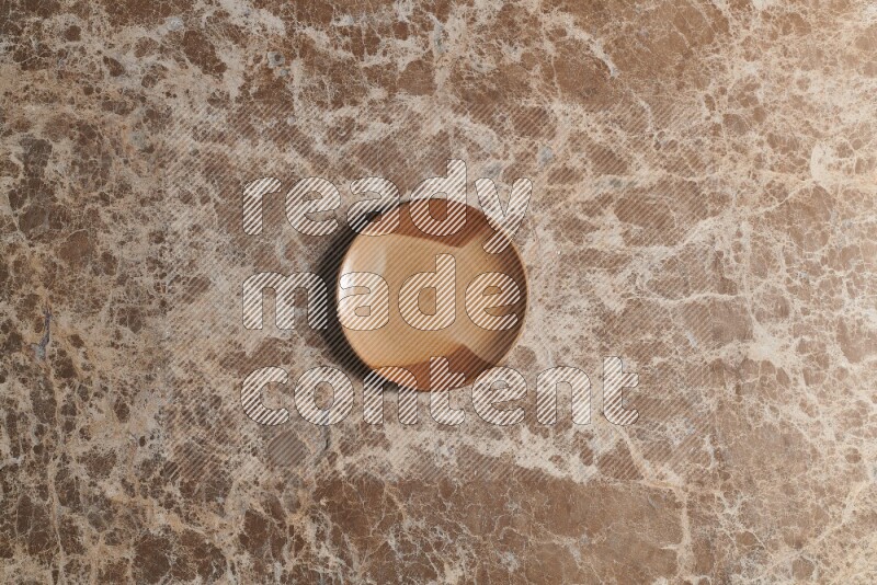 A multicolored pottery plate on beige marble background