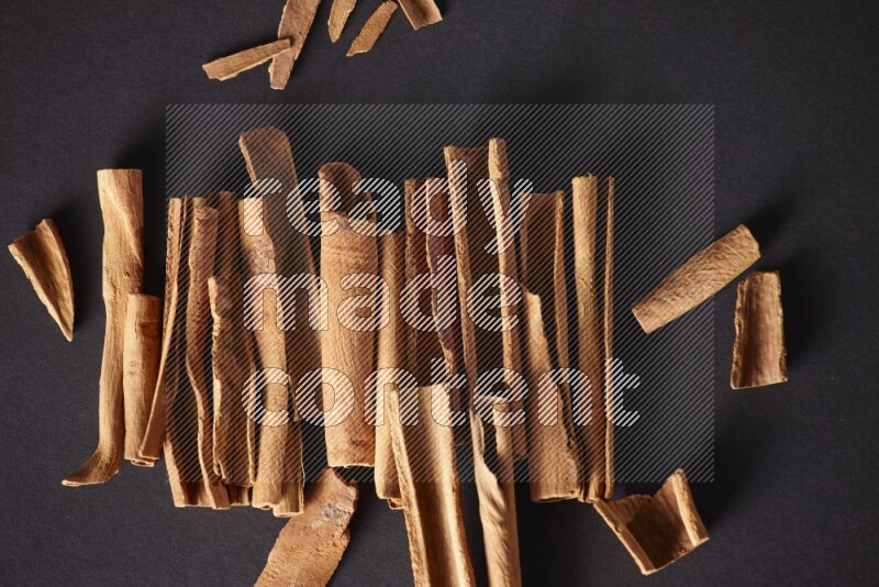 Cracked cinnamon sticks on a black background