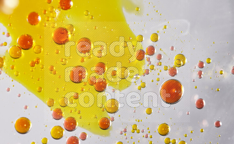 Close-ups of abstract yellow and red watercolor drops on oil Surface on white background