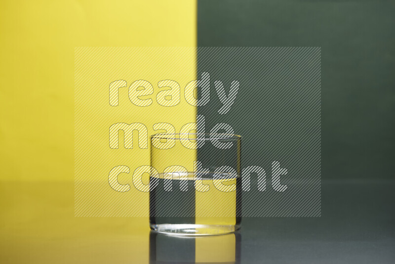 تظهر الصورة أواني زجاجية ممتلئة بالماء موضوعة على خلفية من اللونين الأصفر والأخضر الغامق
