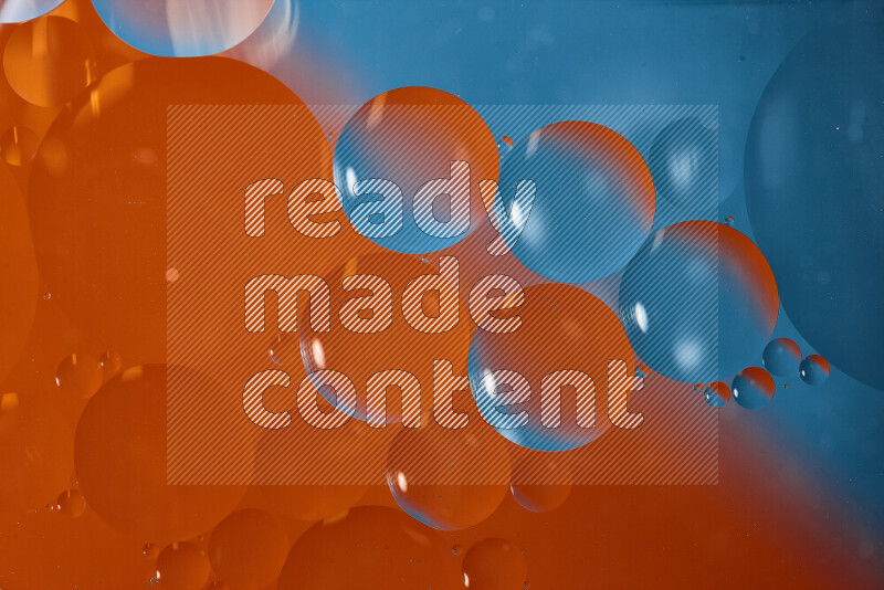 لقطات مقربة لفقاعات من الزيت على سطح الماء باللون الأزرق والبرتقالي