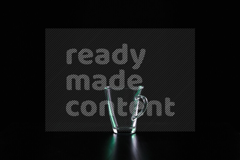 Glassware with rim light in green and white against black background