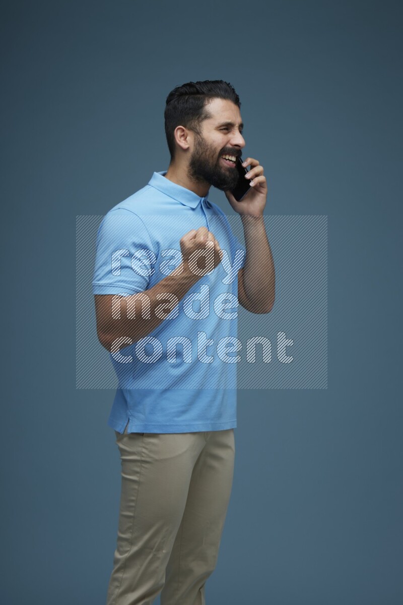 A man having a Call in a blue background wearing a Blue shirt