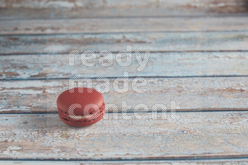 45º Shot of Red Velvet macaron on light blue wooden background